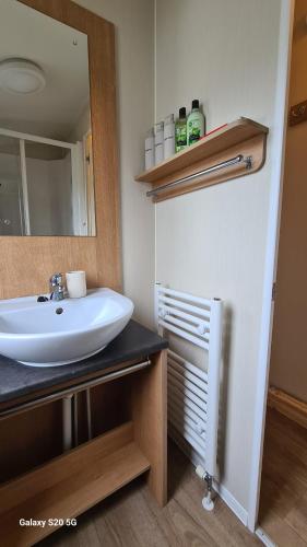 a bathroom with a sink and a mirror at Newydd nook in Anglesey