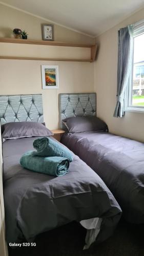 a bedroom with two beds and a window at Newydd nook in Anglesey