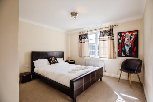 a bedroom with a bed and a chair in it at Spacious 2-Bed Family Flat in Wimbledon Near Tube in London