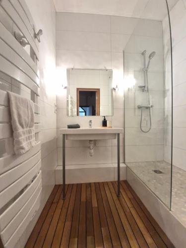 a white bathroom with a sink and a shower at - Magnifique appartement climatisé 92m2, spacieux et cosy, au cœur de Vichy in Vichy