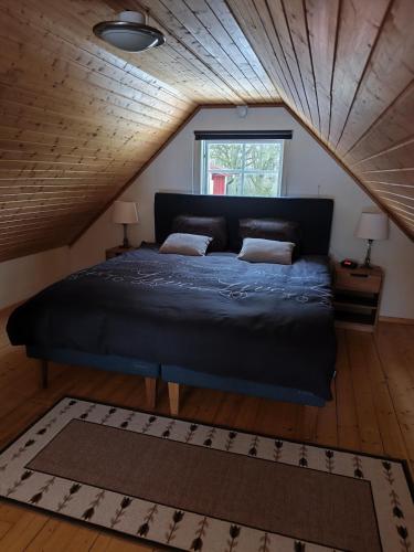 a bedroom with a large bed in a attic at The Red Butterfly 2 cottage in Månstad