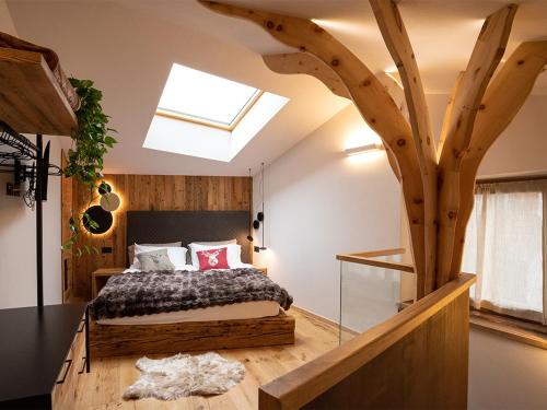 a bedroom with a bed and a tree in the ceiling at SKY LOVE Luxury Chalet in Andalo
