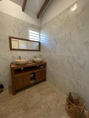 a bathroom with two sinks and a mirror at Le Chalet des Rêves Ensoleillés in Saint-François