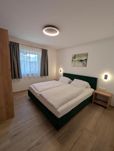a bedroom with a large bed and a window at Apartment Auszeit am See in Uttendorf