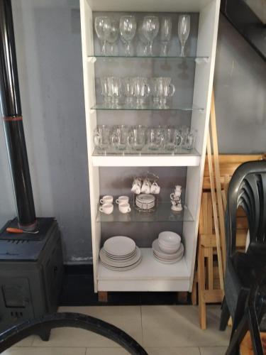 a shelf filled with glasses and plates and a stove at Blend- Casa descanso Cafayate in Cafayate