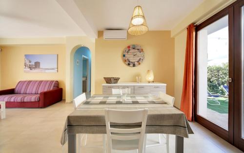 a dining room with a table and a red couch at Borgo Vigata in Punta Secca