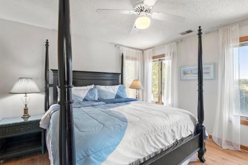a bedroom with a large bed with a ceiling fan at The Sand Wedge in Kitty Hawk