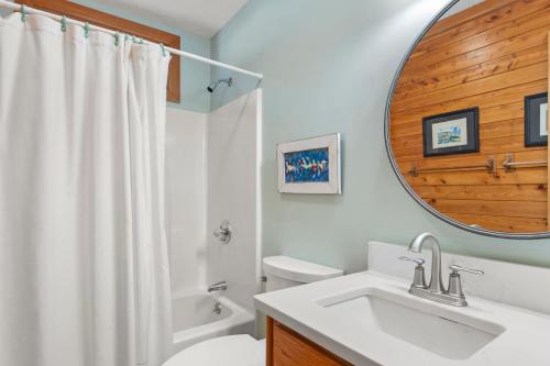 a bathroom with a sink and a toilet and a mirror at The Sand Wedge in Kitty Hawk