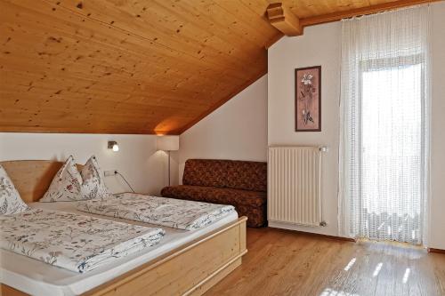 ein Schlafzimmer mit einem Bett und einer Couch in der Unterkunft Ferienwohnung Marienkäfer Rückzugsort inmitten der Natur mit Bergblick in Klobenstein