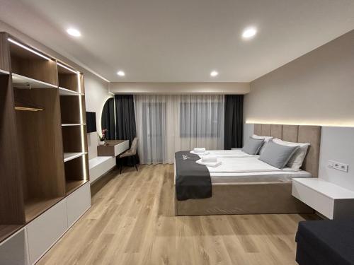 a hotel room with a bed and a desk at Резиденция БАЛМОРА in Kalofer