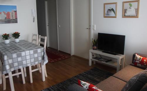 a living room with a table and a television at Apartment Nallisuites in Oulu