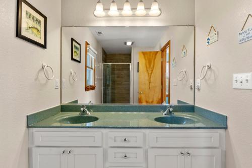 a bathroom with two sinks and a large mirror at Anchors Away in Corolla