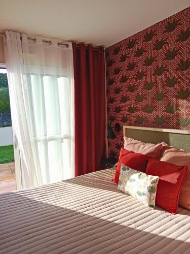 a bedroom with a bed with red walls at L'Instant des Hôtes in Combrit