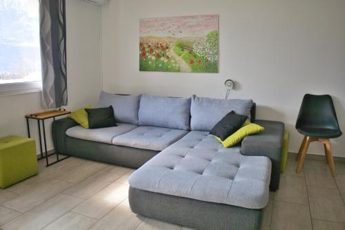a living room with a blue couch and yellow pillows at Apartma Javoršček in Bovec