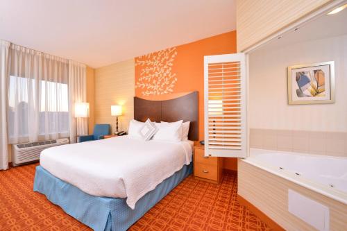 a hotel room with a bed and a bath tub at Fairfield Inn & Suites White Marsh in White Marsh
