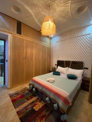 a bedroom with a large bed with a chandelier at maison de bonheur 2 in Tafraout