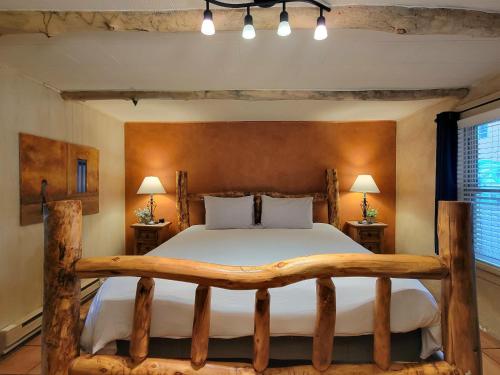 a bedroom with a large bed with a wooden headboard at La Veta Inn in La Veta