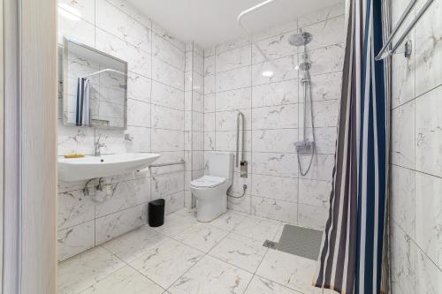 ein weißes Badezimmer mit Waschbecken und Toilette in der Unterkunft Syrtaki Hotel in Ofrynio