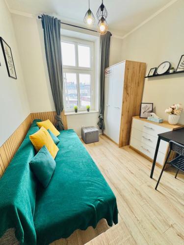 a large green bed in a room with a window at Przy Parku Róż in Chorzów