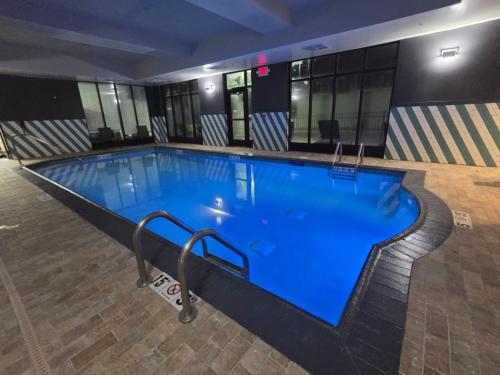 a large swimming pool with blue water in a building at Holiday Inn Saint Louis-Fairview Heights by IHG in Fairview Heights