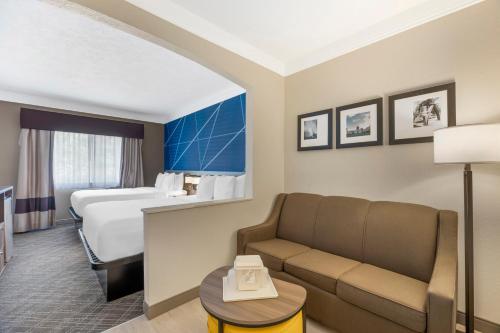 a hotel room with a couch and a bed at Comfort Suites Salem in Salem
