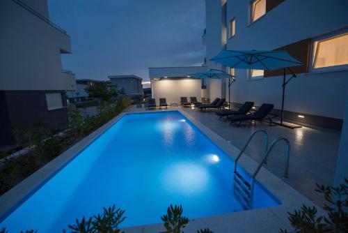 a swimming pool with blue lighting in a house at Pool Apartments & Rooms Mare in Novalja