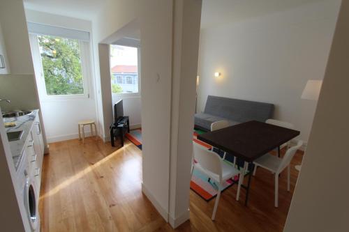 a kitchen and a dining room with a table and a room with a tablektop at OPO.APT - Art Deco Apartments in Oporto's Center in Porto