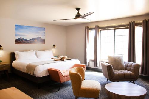 a hotel room with a bed and two chairs at Cuchara Lokal in La Veta