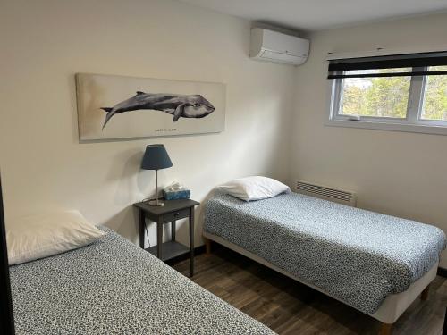 a bedroom with two beds and a picture of a whale at Les Chalets du Lac Serein --Serein-- in Saint Ludger de Milot