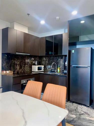 a kitchen with a white table and a refrigerator at Clasio - Lumiere Riverside in Ho Chi Minh City