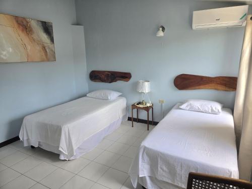 due letti in una stanza con pareti blu di The Gardens a Kingston