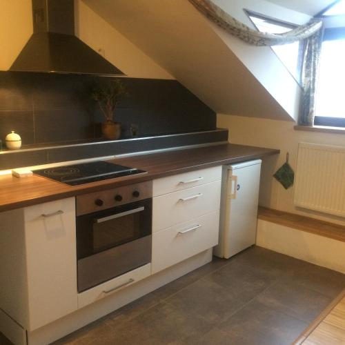 a kitchen with a stove top oven next to a window at Apartmán Slovinská 28 in Brno