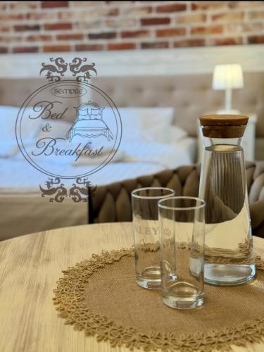 a bottle and two glasses sitting on a table at Sempre B&B in Płock