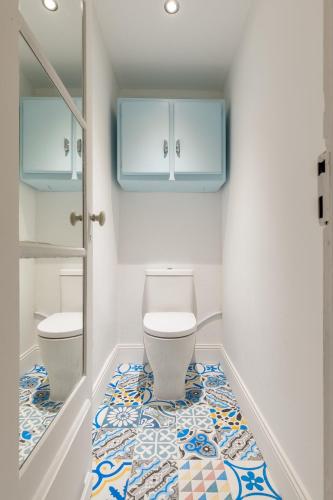 a bathroom with a toilet and a tile floor at Les Deux Clefs in Mont-de-Marsan