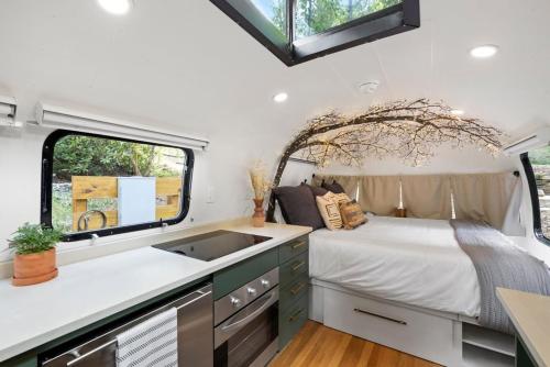 a kitchen with a bed and a sink in a trailer at Airstream w Bathtub, River, & Hot Tub in Pisgah Forest