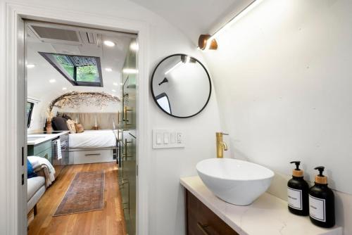 a bathroom with a sink and a mirror on the wall at Airstream w Bathtub, River, & Hot Tub in Pisgah Forest