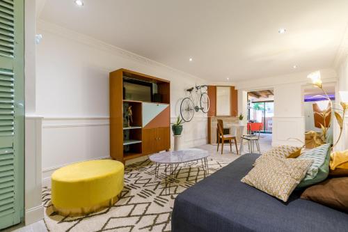 a living room with a couch and a yellow stool at Les Deux Clefs in Mont-de-Marsan