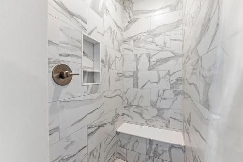 a white marble shower with a bench in a bathroom at Wax Turtle in Southern Shores