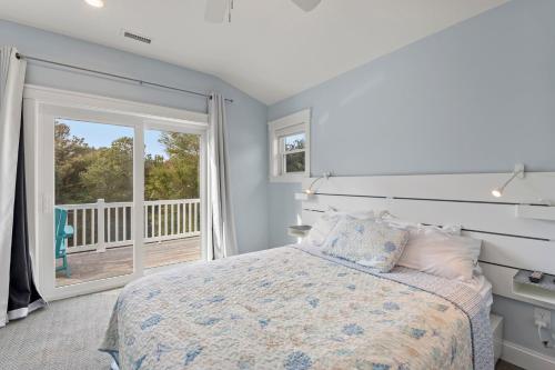 a bedroom with a bed and a balcony at Wax Turtle in Southern Shores