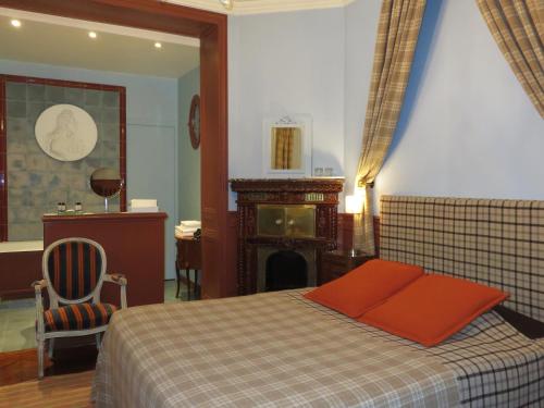 a bedroom with a bed with a red pillow and a fireplace at Hotel Windsor Home in Paris
