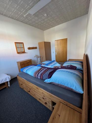 a bedroom with a large wooden bed with blue sheets at Steigerstube in Clausthal-Zellerfeld