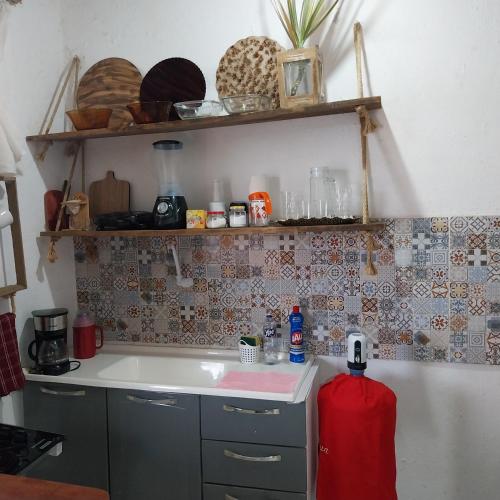 a kitchen with a sink and a red fire extinguisher at Espaço familiar in Saquarema
