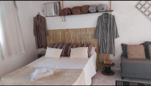 a small room with a bed and a couch at Espaço familiar in Saquarema