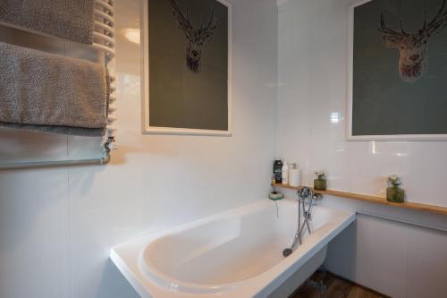 a bathroom with a white tub and a sink at Dream Forest Cabin -dom w lesie pod Warszawą in Warsaw