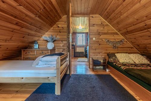 a bedroom with two beds in a log cabin at Dream Forest Cabin -dom w lesie pod Warszawą in Warsaw
