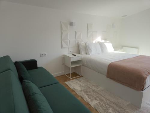 a bedroom with a bed and a couch at Raposa Verde - Agroturismo in Pegarinhos