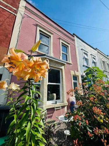 a house with a yellow flower in front of it at Totterdown's Fabulous House & Floral Garden in Bristol