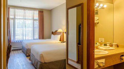 a hotel room with two beds and a sink at Cahilty #120 home in Sun Peaks