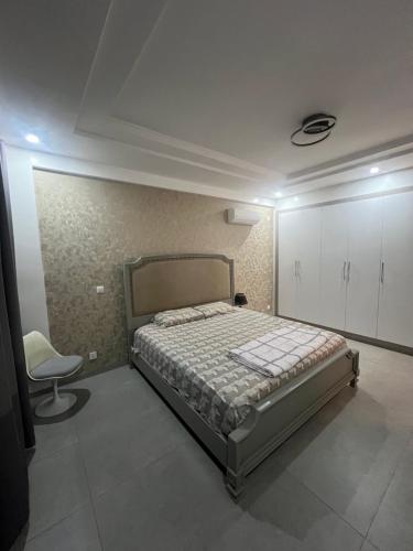 una camera da letto con un letto e una sedia di Tasmanie B1 a Ouakam