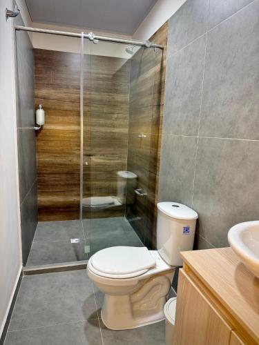a bathroom with a toilet and a glass shower at Amazonía Luxury in Florencia